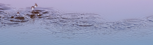 Raindrops splashing into water