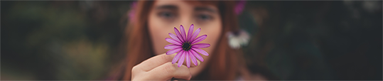 Pink flower held by woman